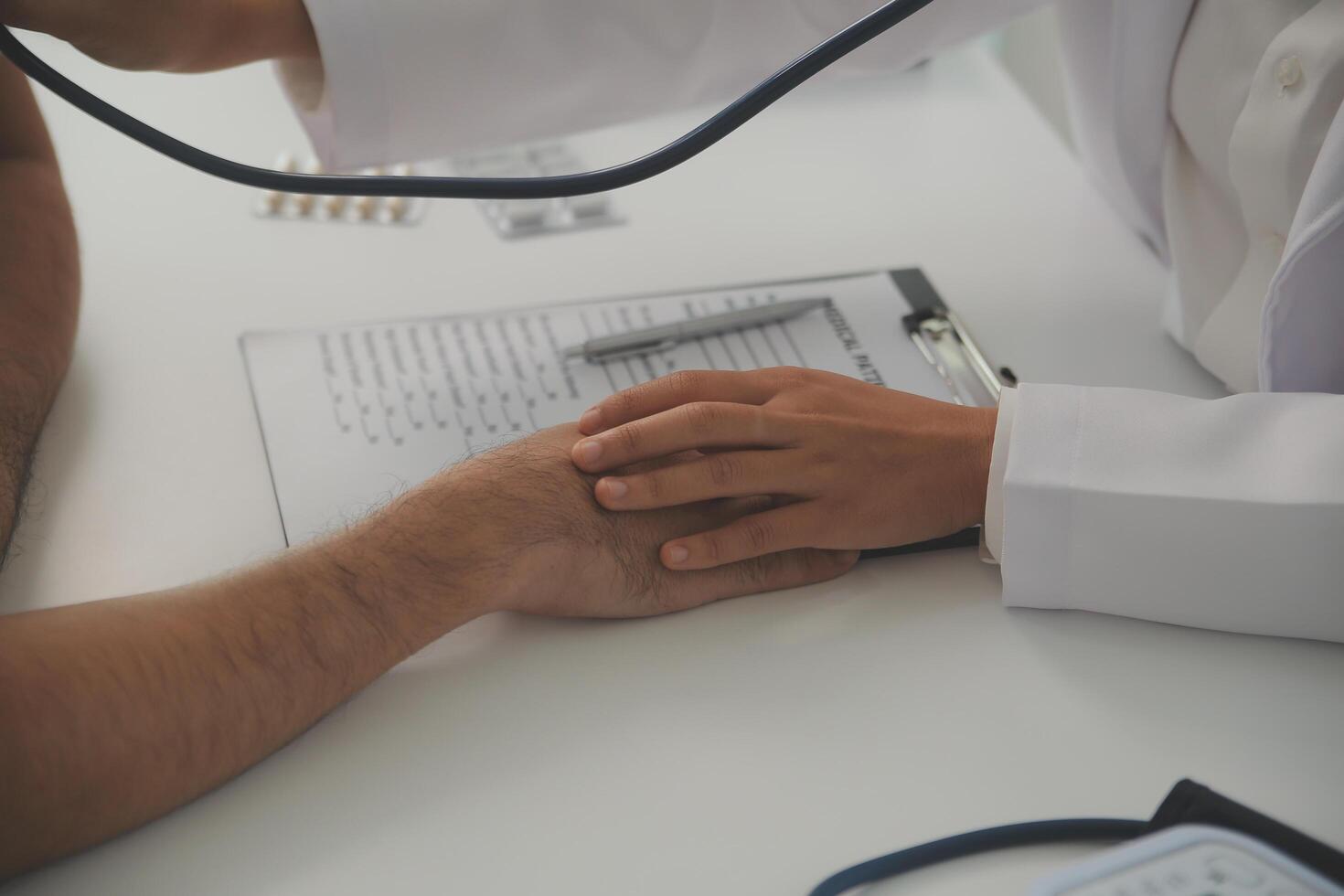 Young doctor is using a stethoscope listen to the heartbeat of the patient. Shot of a female doctor giving a male patient a check up photo