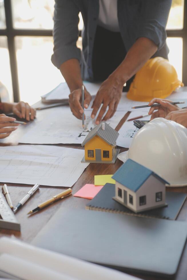 A team of construction engineers talks to managers and construction workers at the construction site. Quality inspection, work plan, home and industrial building design project photo