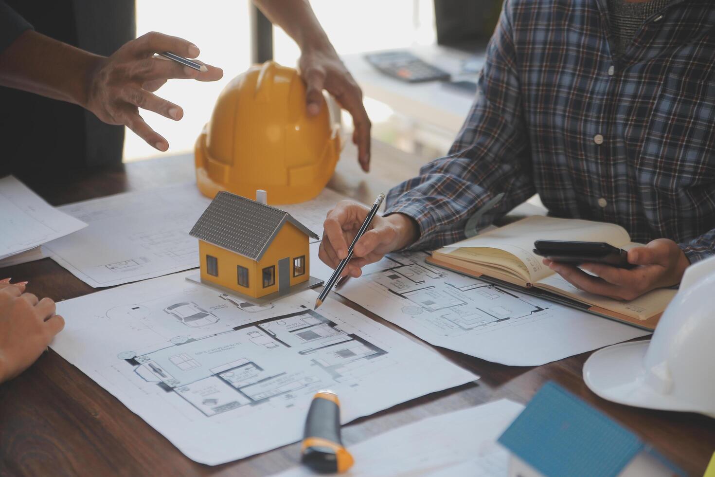 A team of construction engineers talks to managers and construction workers at the construction site. Quality inspection, work plan, home and industrial building design project photo