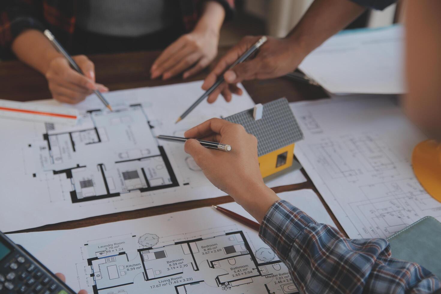 A team of construction engineers talks to managers and construction workers at the construction site. Quality inspection, work plan, home and industrial building design project photo