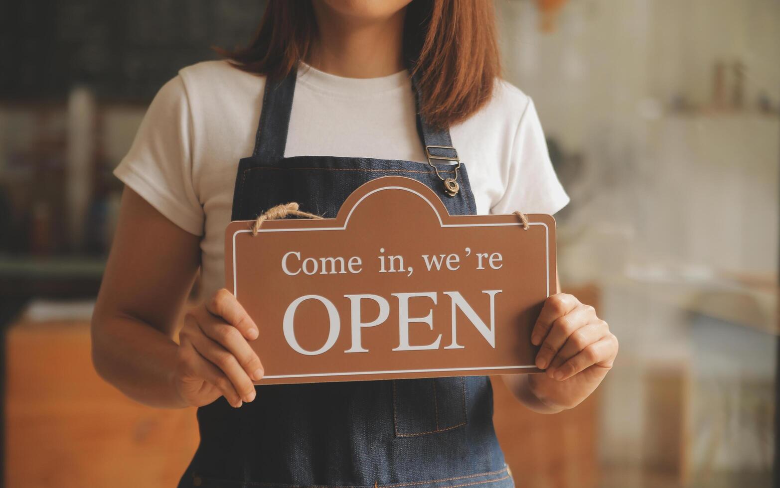Startup successful small business owner sme beauty girl stand with tablet smartphone in coffee shop restaurant. Portrait of asian tan woman barista cafe owner. SME entrepreneur seller business concept photo