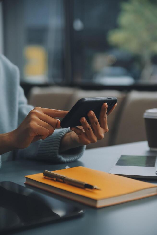 Happy pretty millennial Indian girl relaxing at home, resting in armchair, typing on smartphone, using online app, software, shopping on Internet, making video call. Mobile phone communication photo