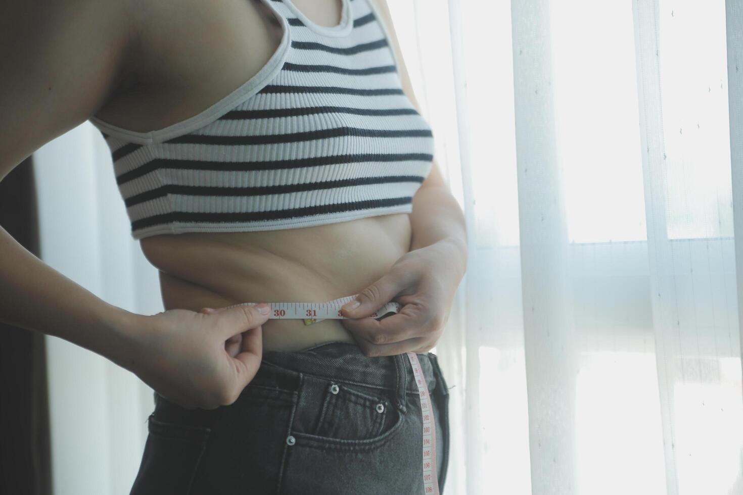 Women body fat belly. Obese woman hand holding excessive belly fat. diet lifestyle concept to reduce belly and shape up healthy stomach muscle. photo