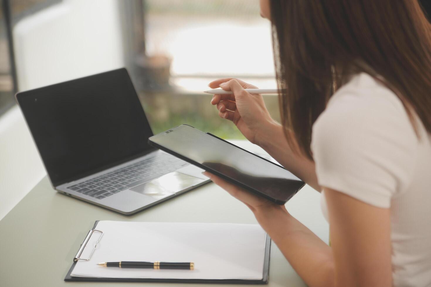 Asian businesswoman working on laptop computer Look for job online, freelance looking and typing on notebook on table, lifestyle of woman studying online photo