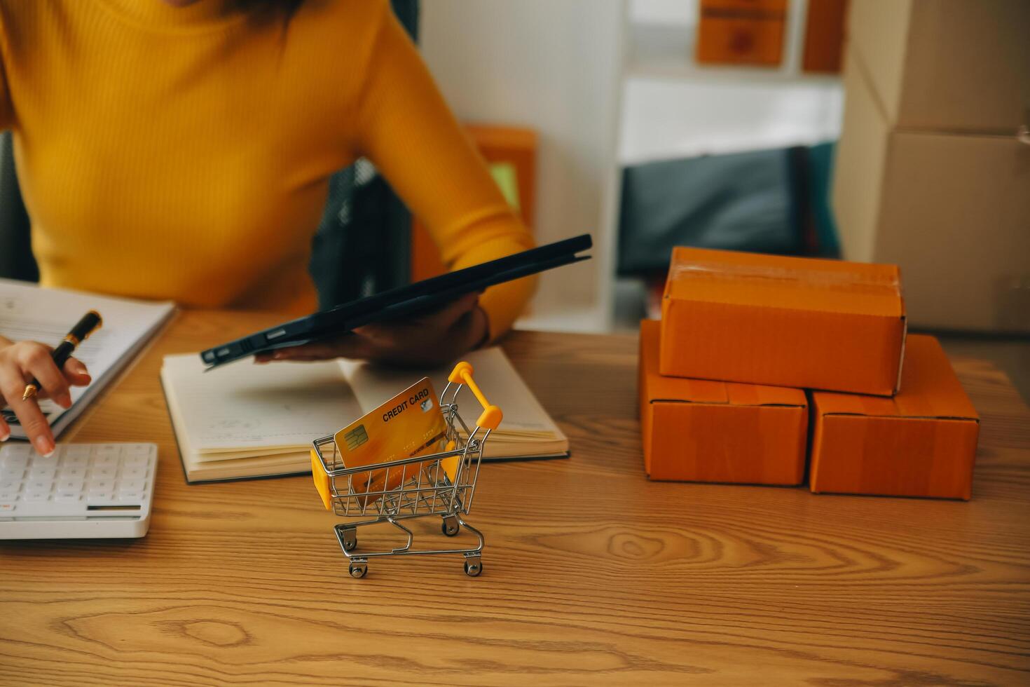 Young woman small business owner online shopping at home. taking note of orders from customers with mobile phones. SME entrepreneur or freelance life style concept. photo