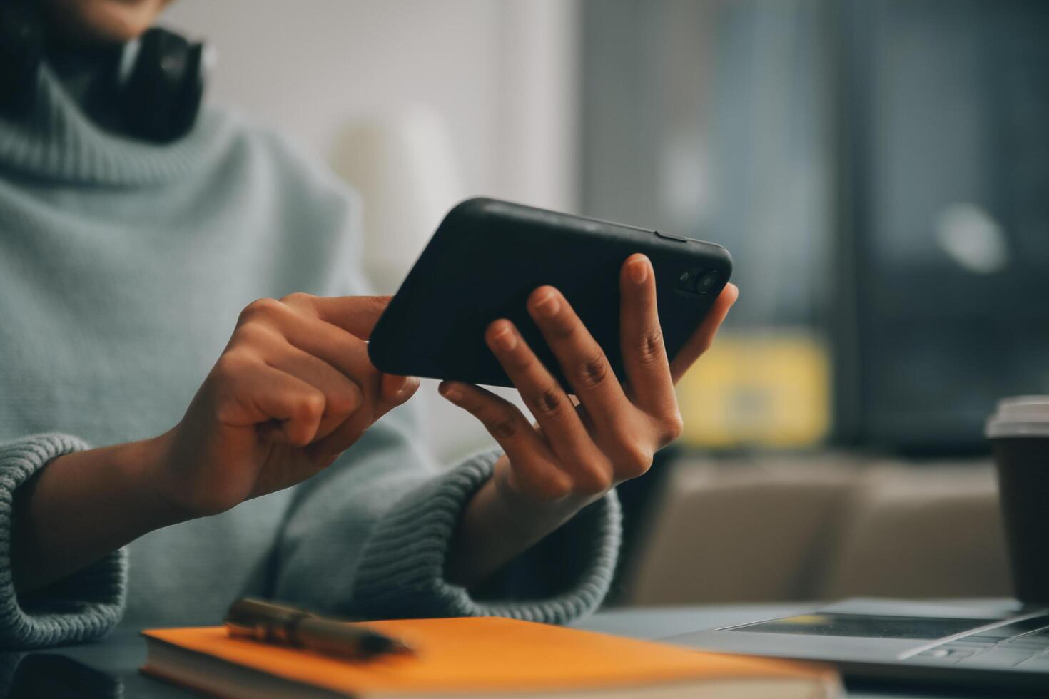 Happy pretty millennial Indian girl relaxing at home, resting in armchair, typing on smartphone, using online app, software, shopping on Internet, making video call. Mobile phone communication photo