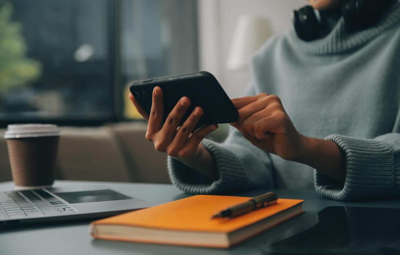 Happy pretty millennial Indian girl relaxing at home, resting in armchair, typing on smartphone, using online app, software, shopping on Internet, making video call. Mobile phone communication photo