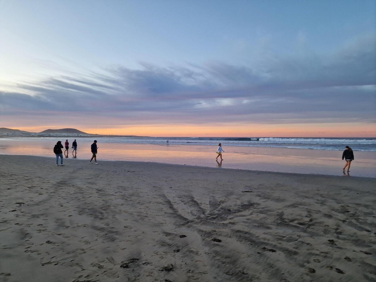 puesta de sol en famara playa en lanzarote isla foto