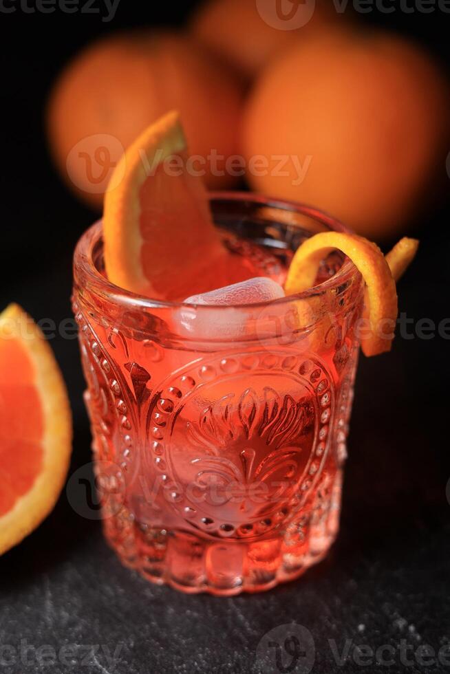 clásico negroni cóctel en un retro vaso con hielo y rebanado naranja foto