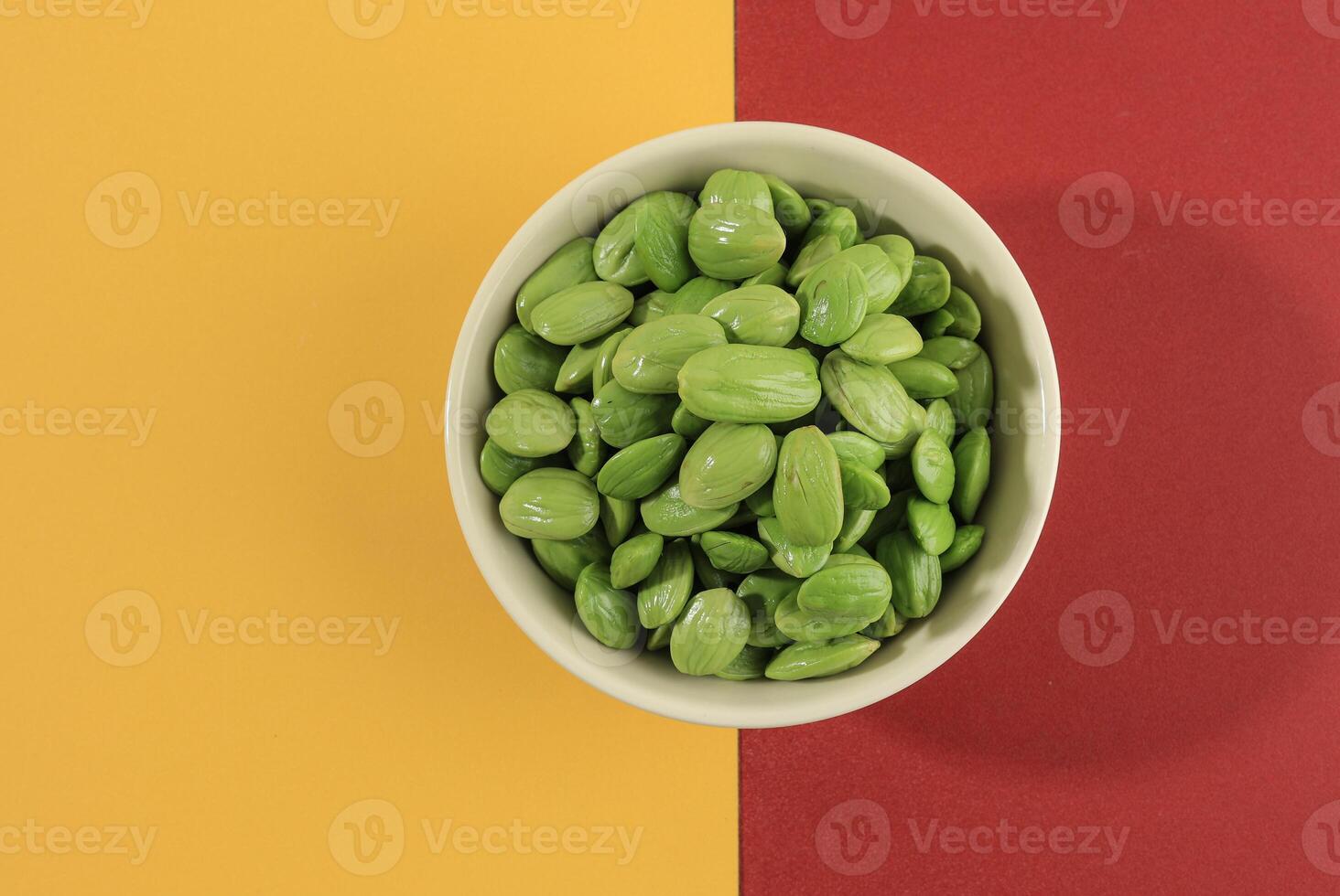 Petai or Pete Stinky Bean on White Ceramic Bowl, Peeled from the Skin. photo