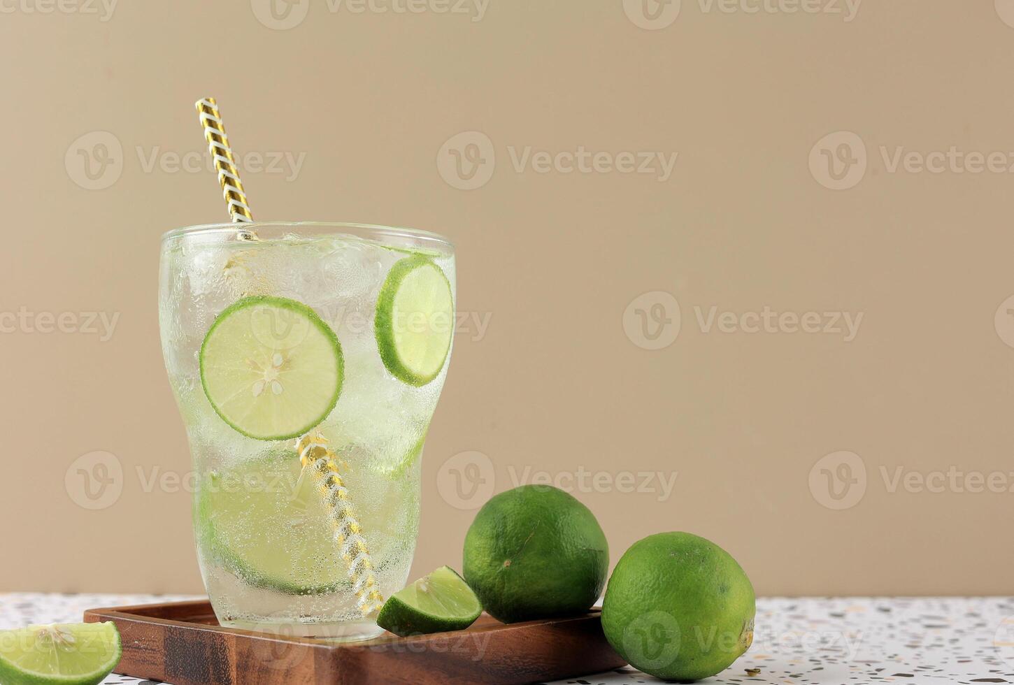 Refreshing Lime Soda with Ice Cube in Tall Glass with Paper Straw photo