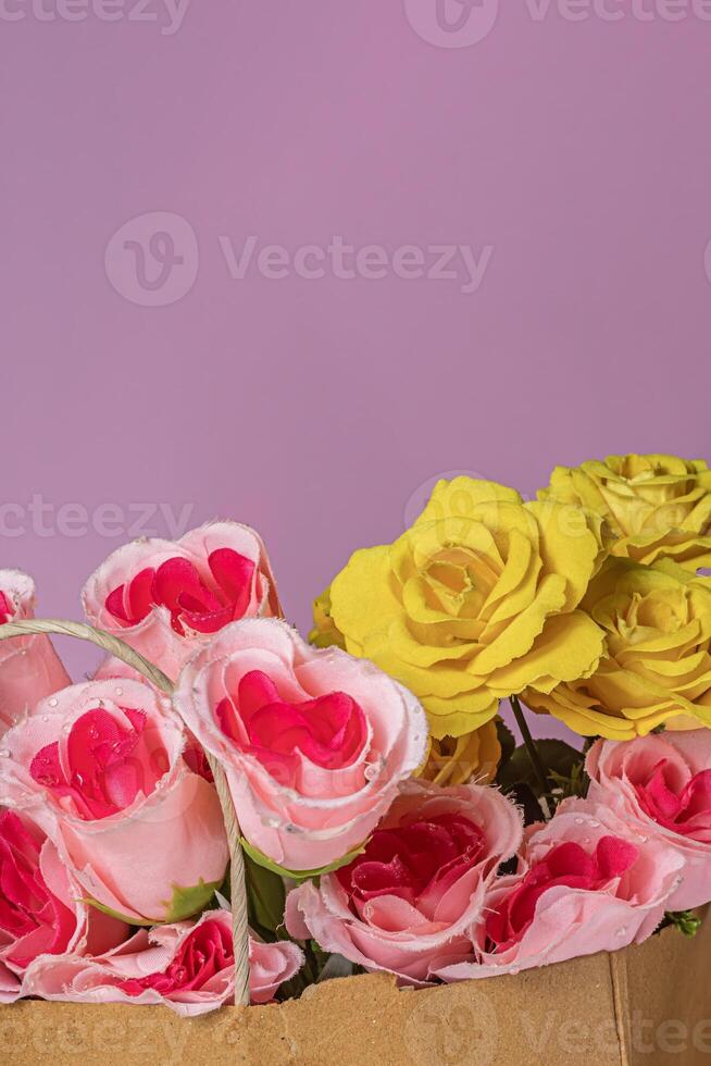 Bouquet of roses in a paper bag on a pink background with copy space for your text. photo