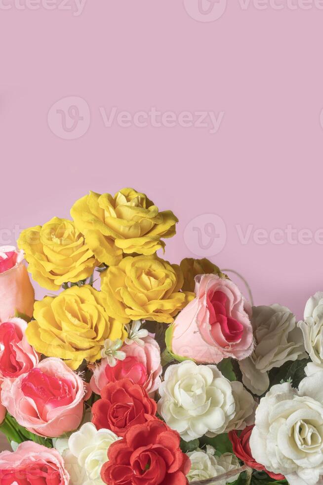 Bouquet of colorful roses on pink background with copy space. photo