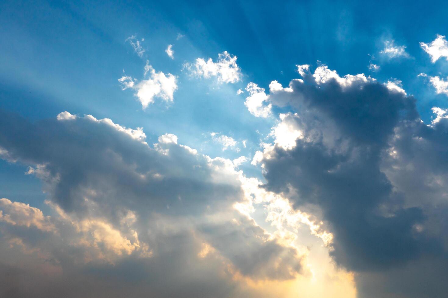 Beauty of the clouds in the sky that glow with an orange light. The rays of the evening sun escape through the clouds. Background of blue sky. photo