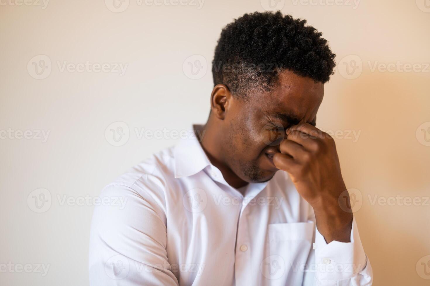 Portrait of young businessman who is tired and having headache. photo