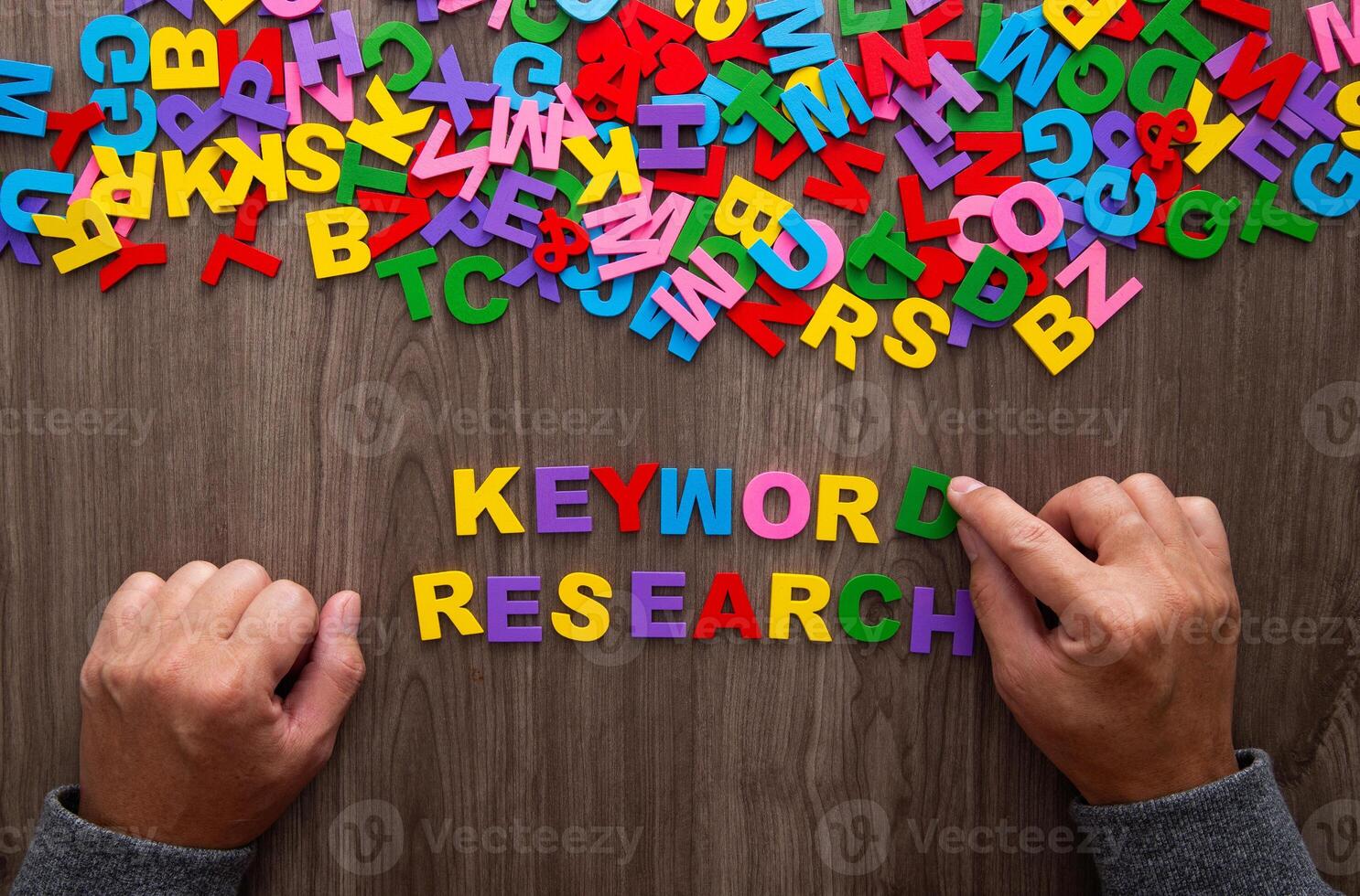 Hand arrangging color letters of the alphabet, Keyword Research photo