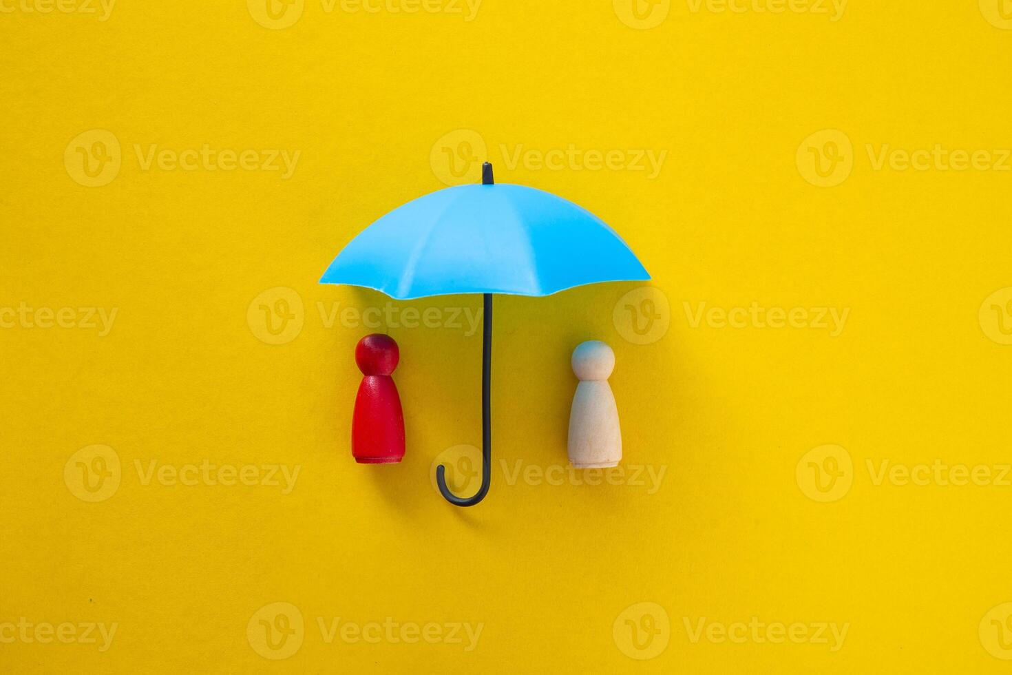 Blue toy umbrella and wooden doll figures. photo