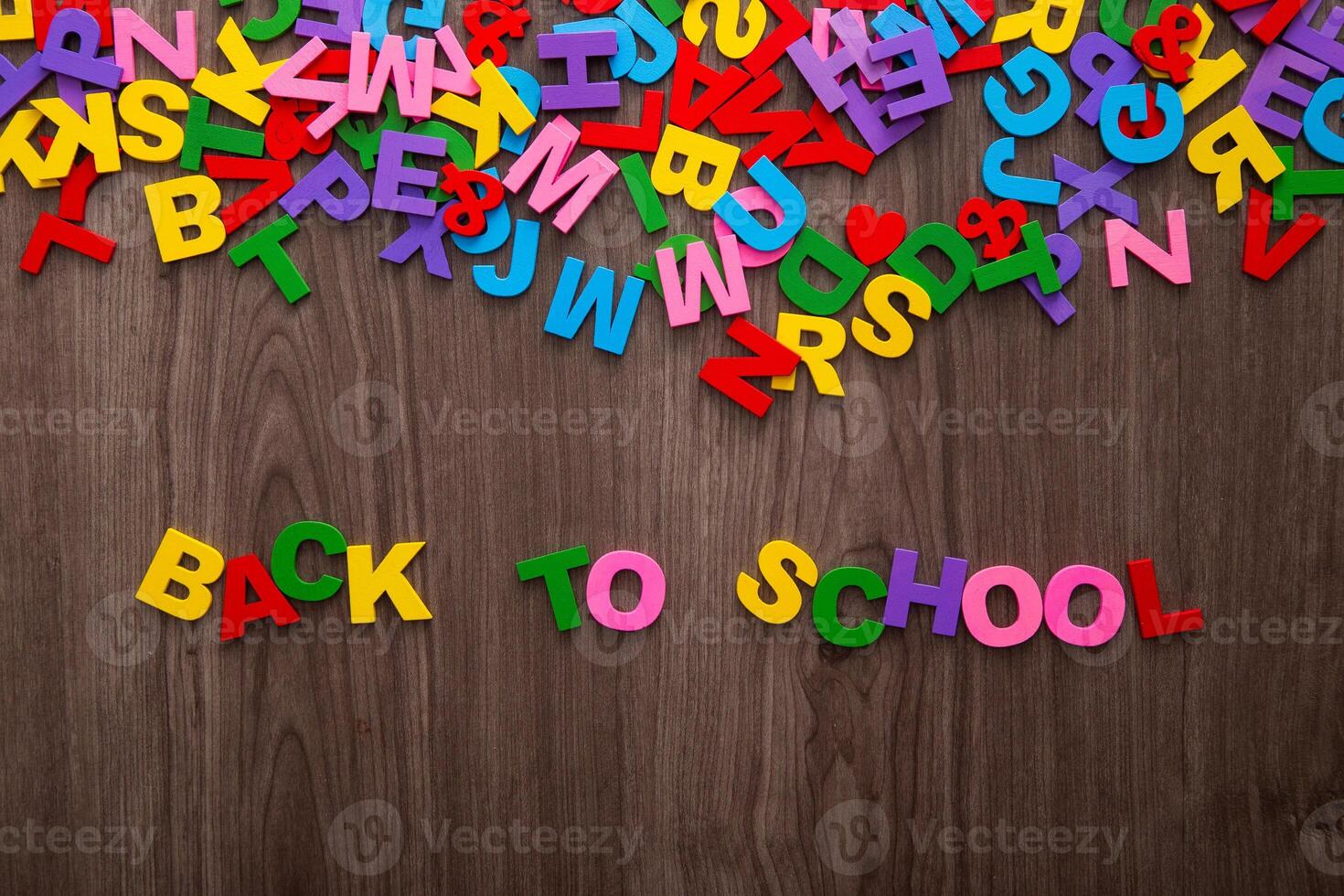 Back to school sign formed from colorful plastic letter on wooden background photo