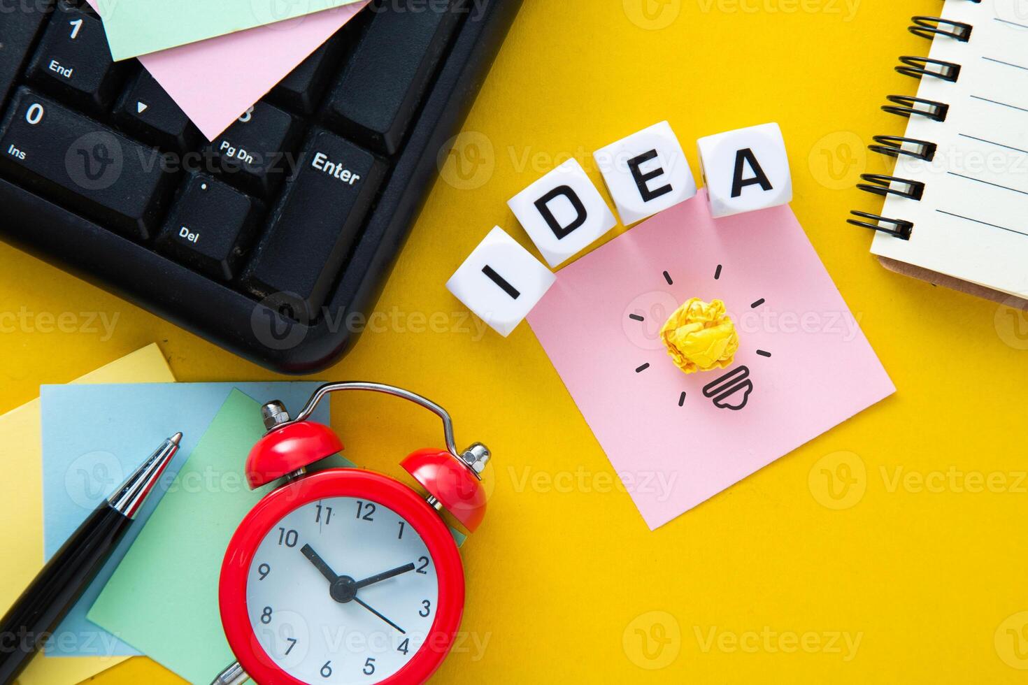 The words idea on yellow background  with a light bulb. photo