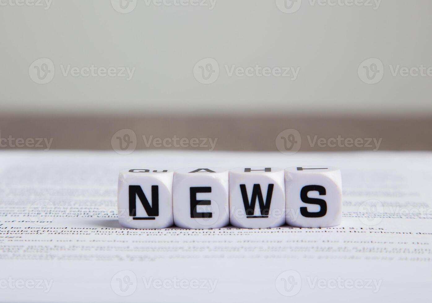 the word news on cubes on a newspaper photo