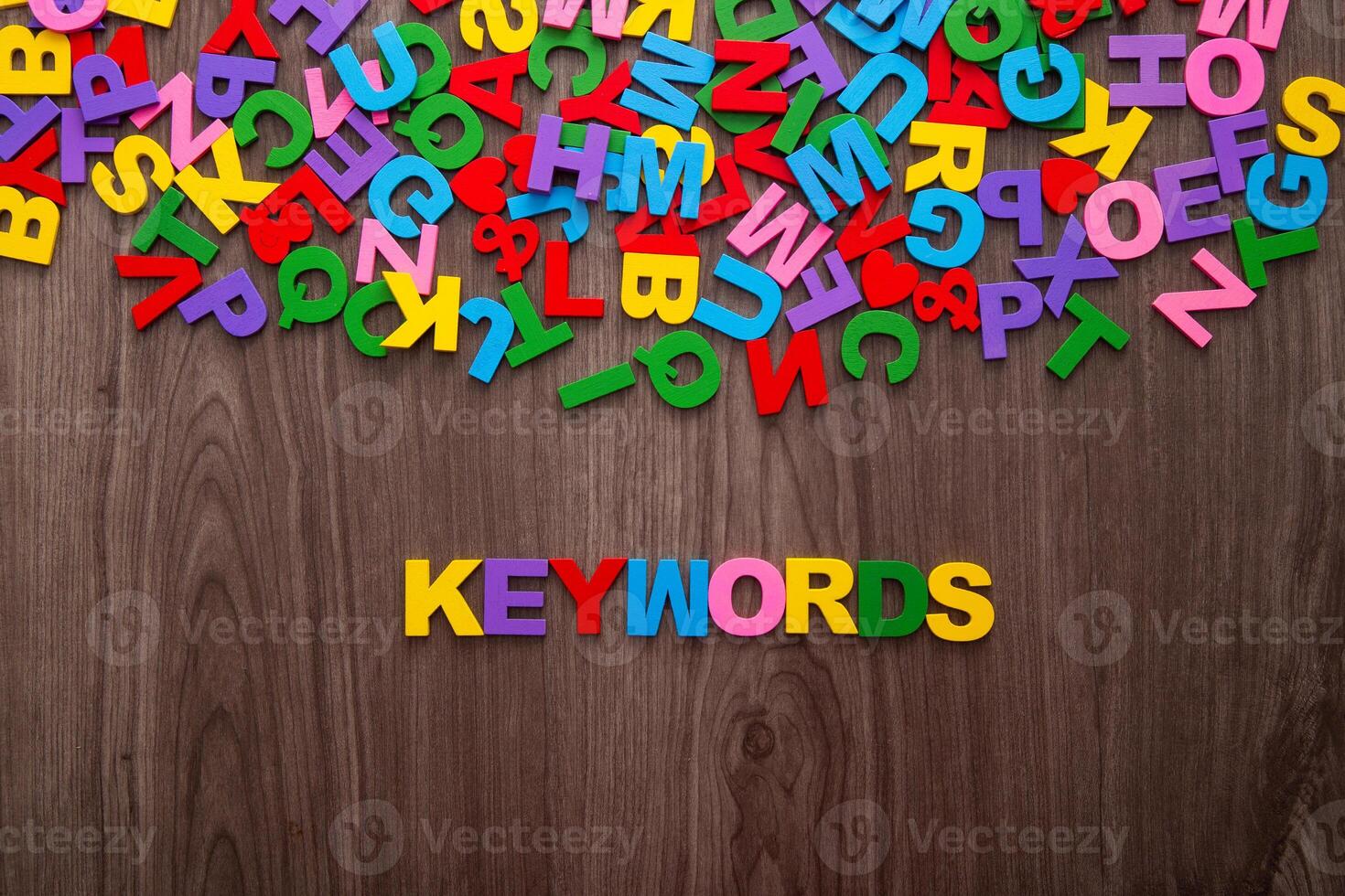 Color letters of the alphabet and the word KEYWORDS on wooden background photo