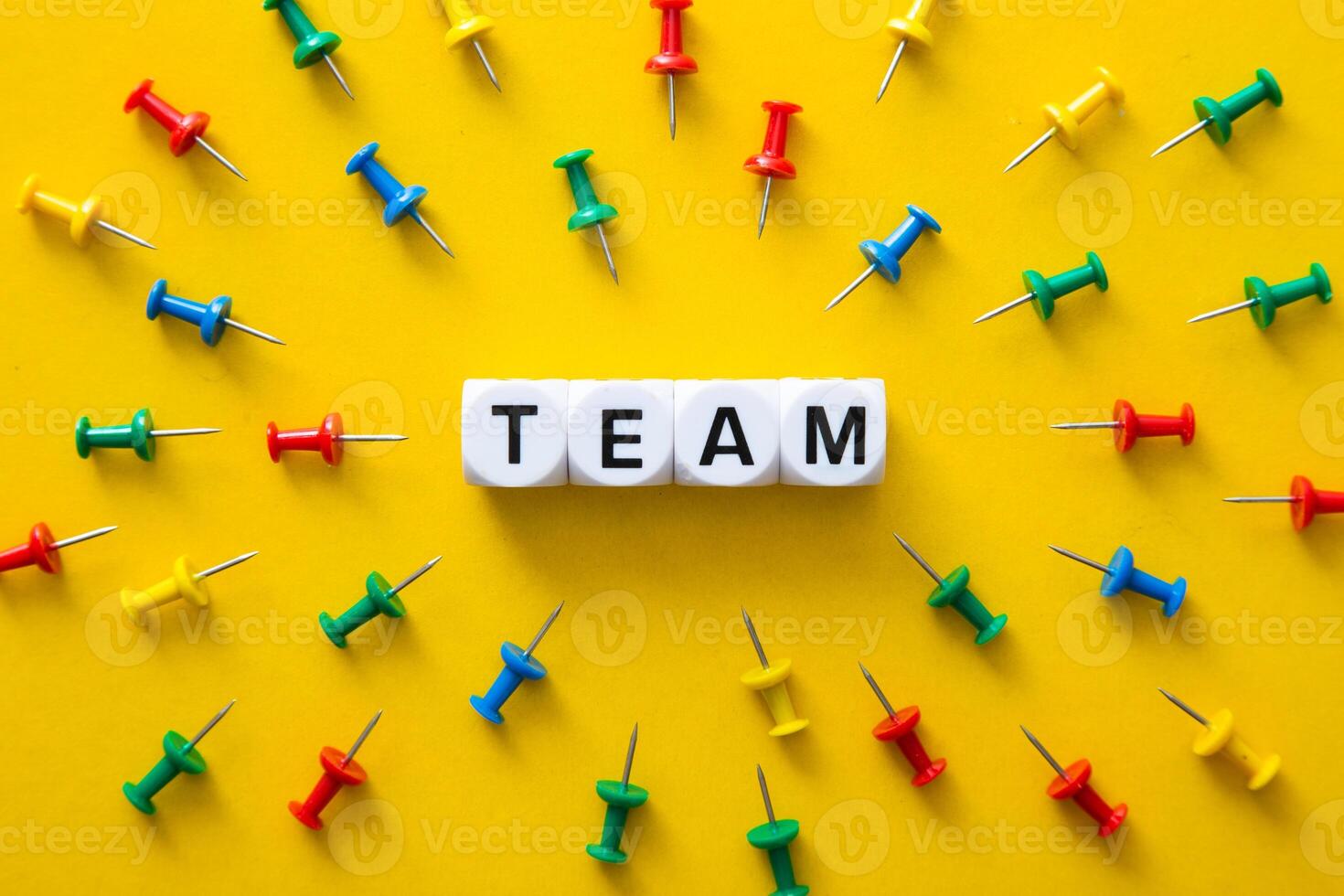 Color push pins with their spike pointed to the block with TEAM word. Business Conceptual photo