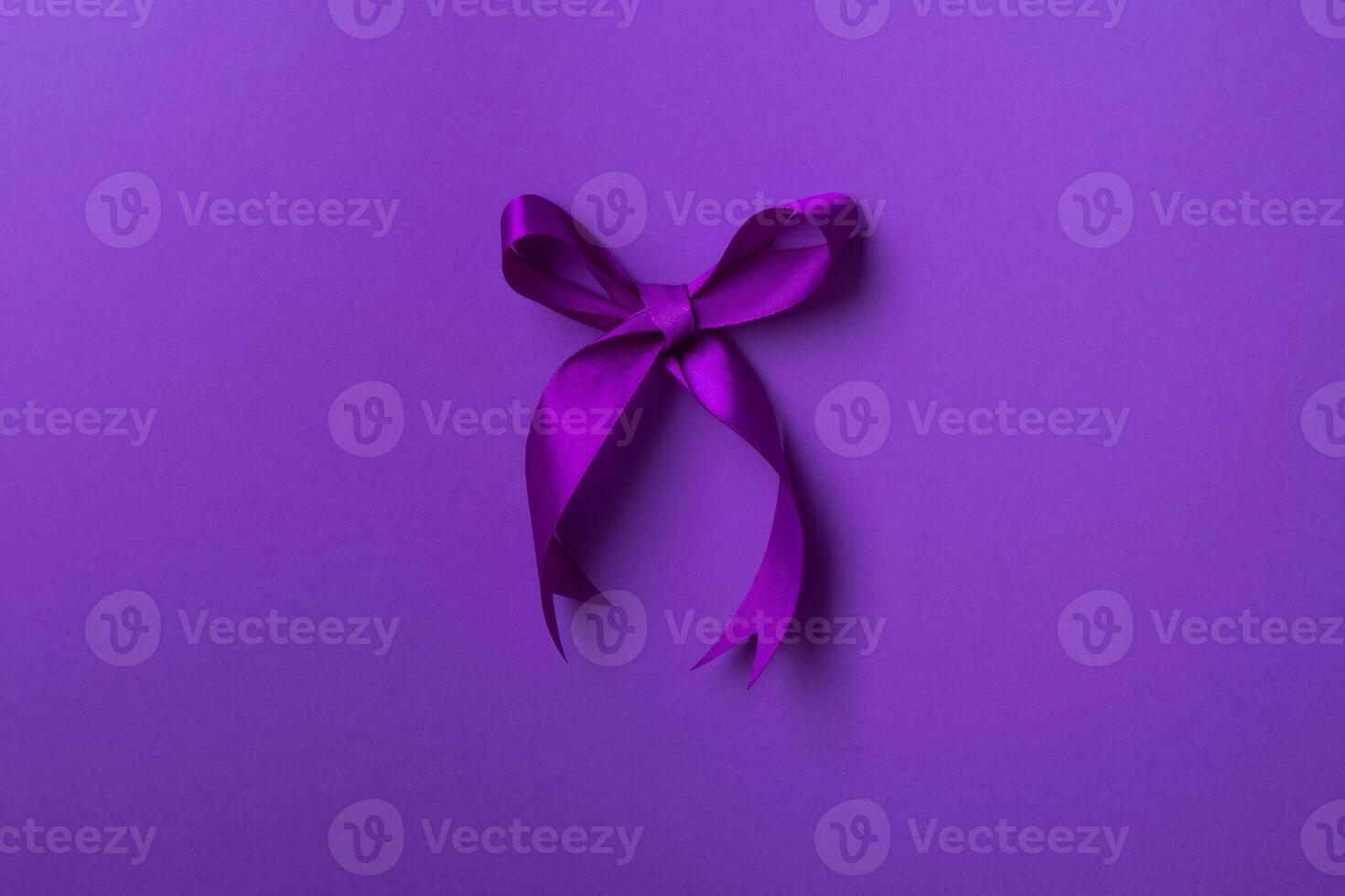 Purple bow ribbon isolated on purple background. photo