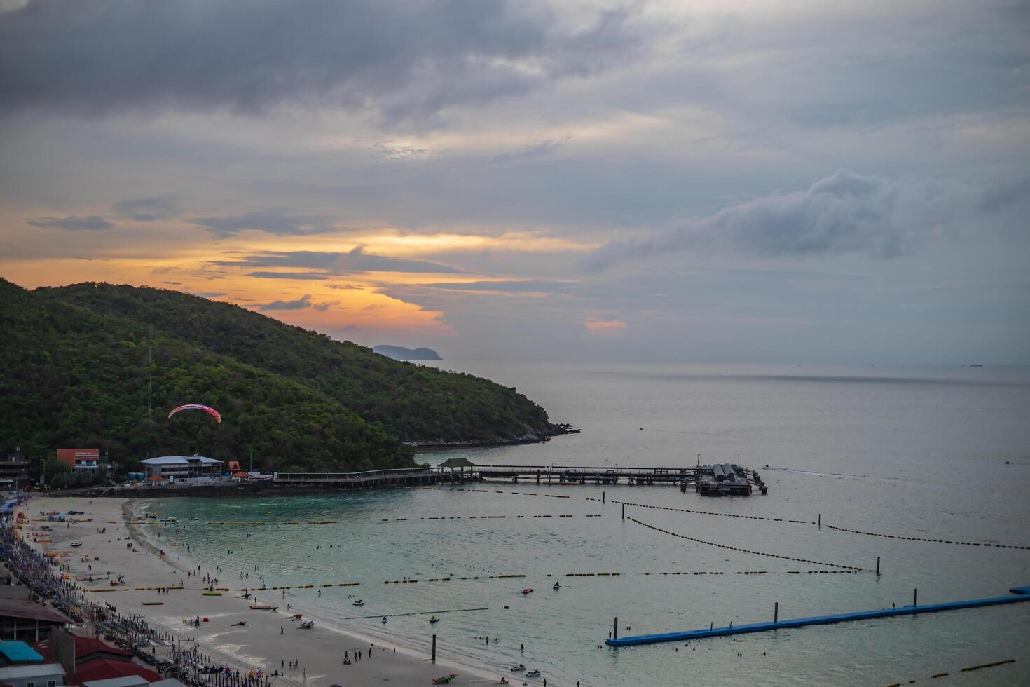 Sunset view of tawean beach with crowded of tourist on the beach in cloudy day.Tawaen Beach is the main Beach on the popular Koh Larn Island. photo