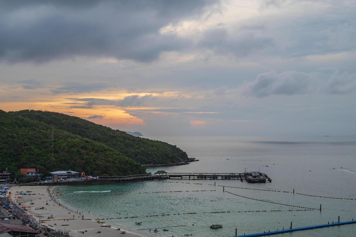 puesta de sol ver de taweano playa con concurrido de turista en el playa en nublado dia.tawaen playa es el principal playa en el popular koh larn isla. foto