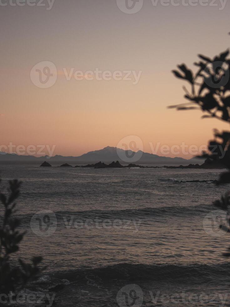 Distant snowy mountain across the ocean photo