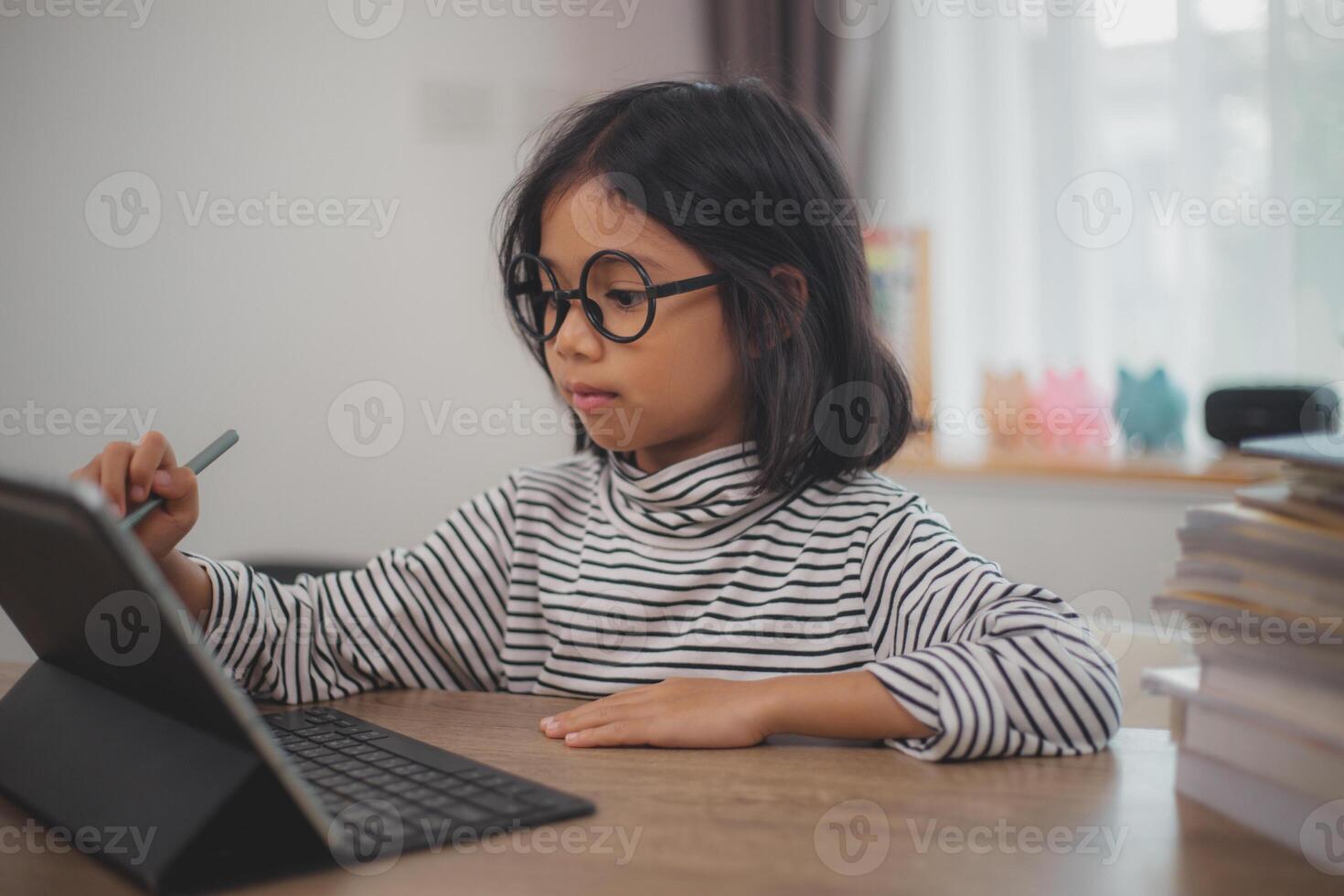 linda asiático pequeño niña niños utilizando un ordenador portátil computadora, estudiando mediante un en línea e-learning sistema. foto