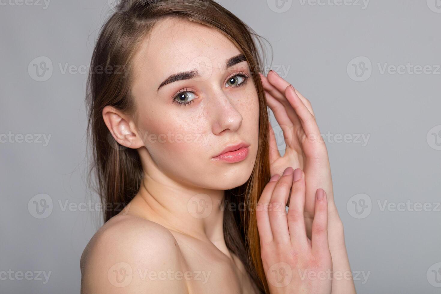 Beautiful Young Woman with Clean Fresh Skin touch own face . photo