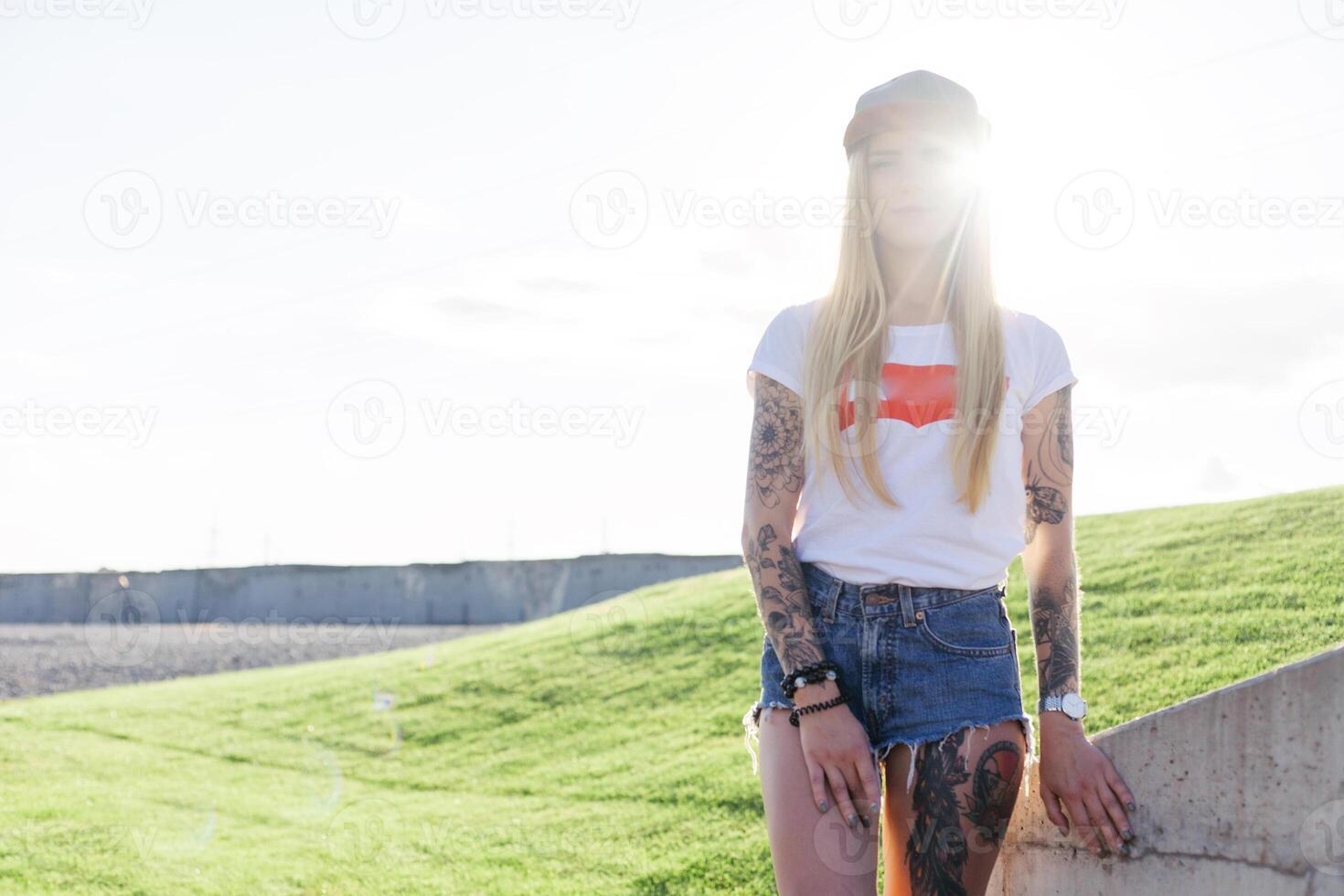 Portrait of a hipster young girl smiling with a longboard at sunset. photo