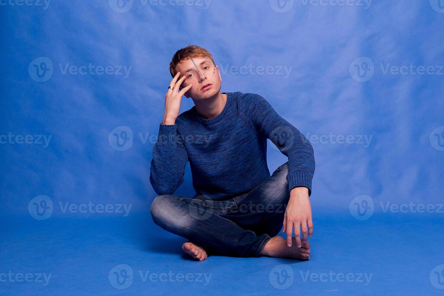 retrato de un adulto hermoso elegante pacífico hombre en un azul suéter foto