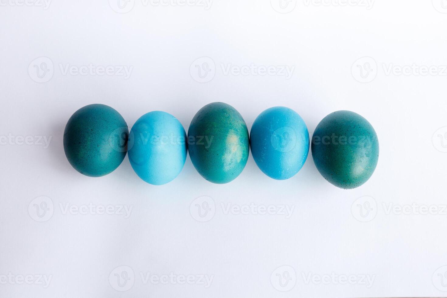 Row of ombre blue Easter eggs isolated on white background photo