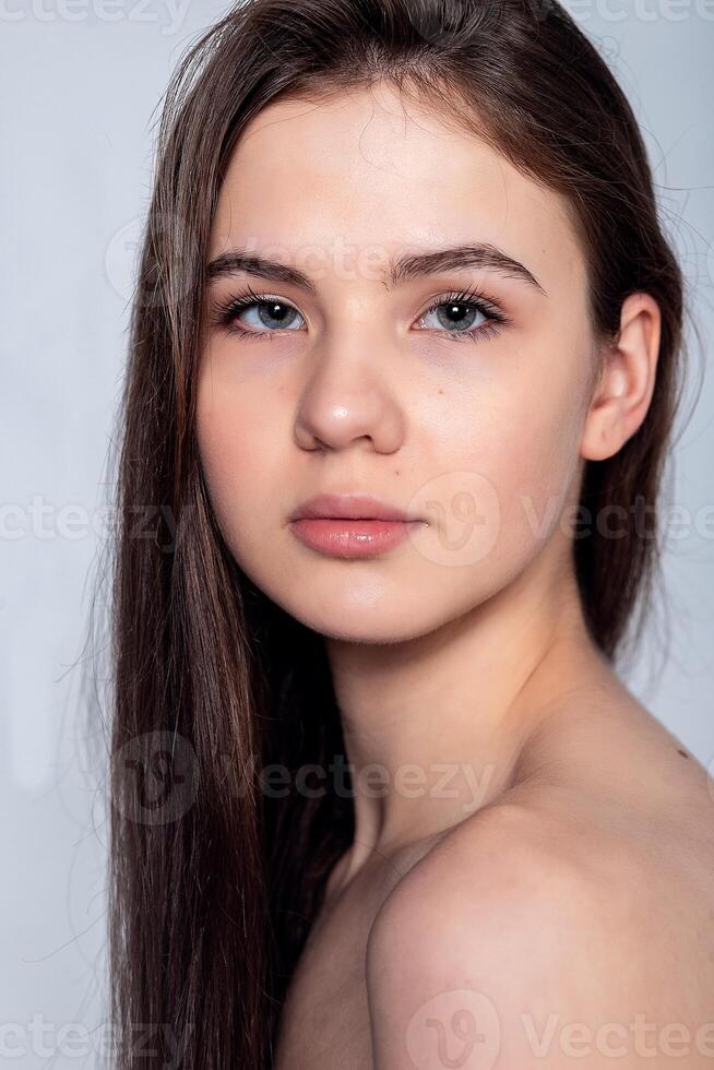 Beautiful Young Woman with Clean Fresh Skin touch own face . photo