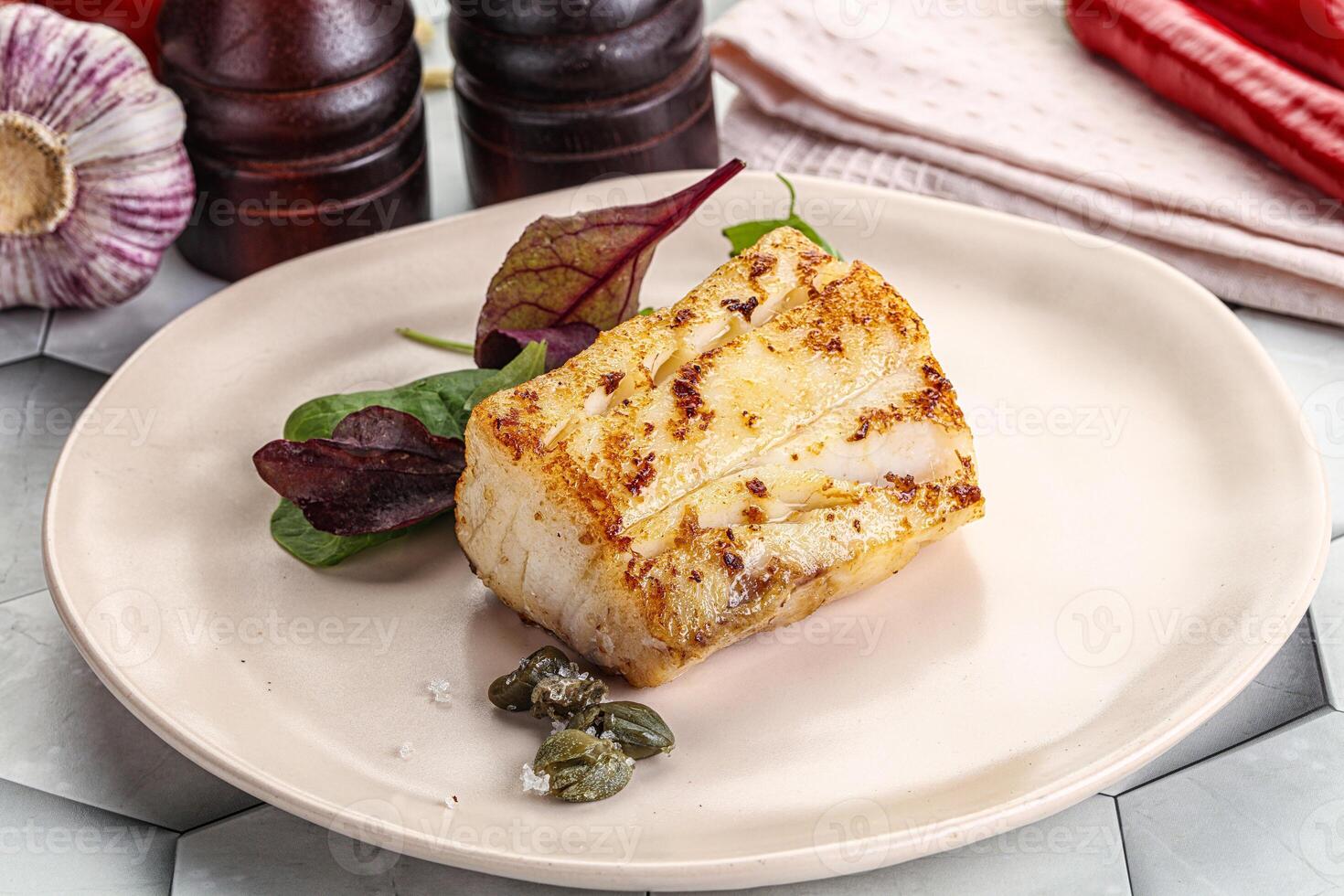 Roasted cod fish steak with salad photo