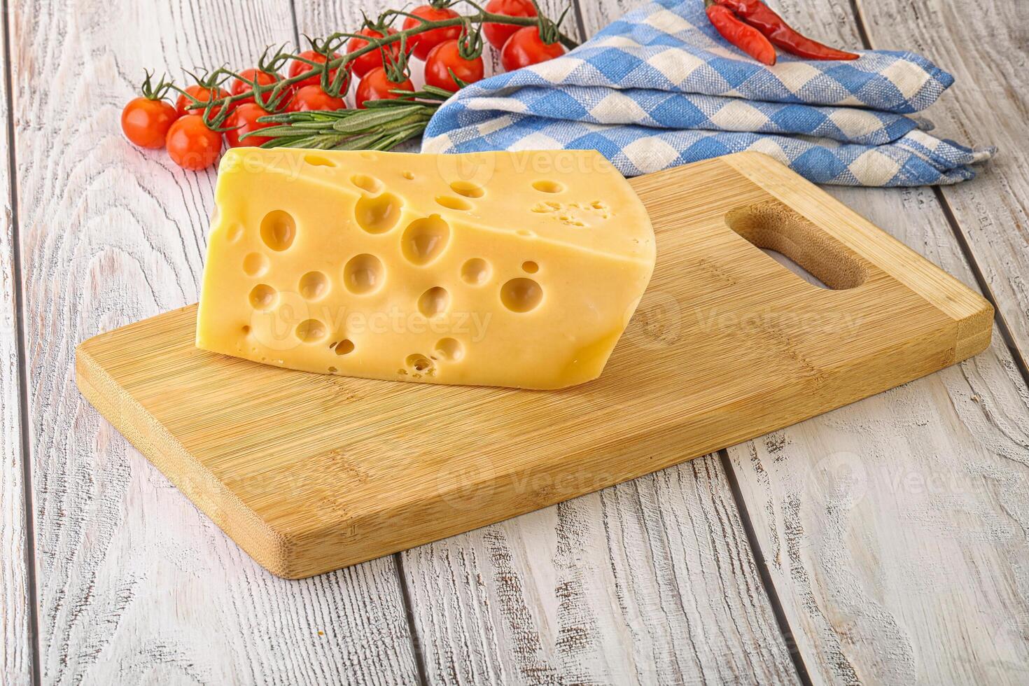 Maasdam cheese piece over board photo