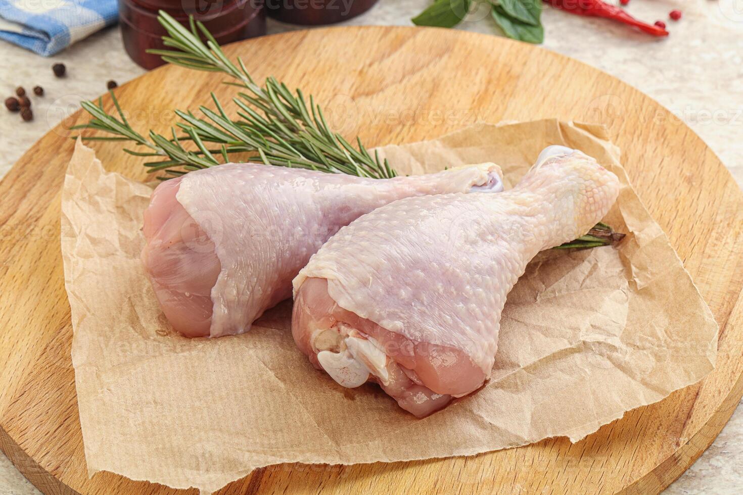 Raw chicken leg over board photo