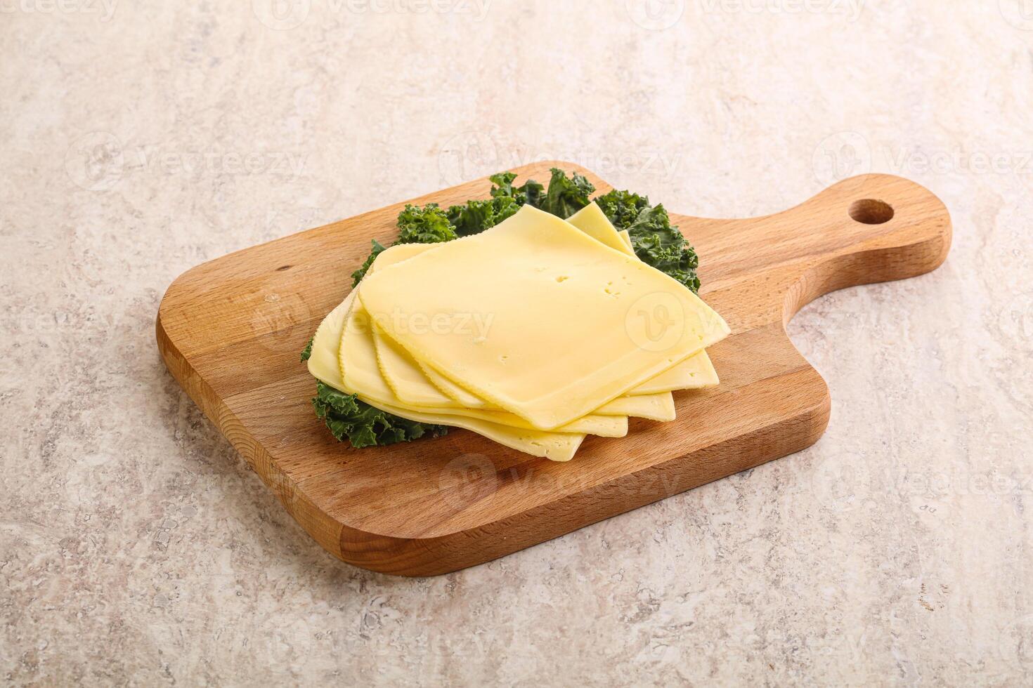 Sliced Gouda cheese over board photo