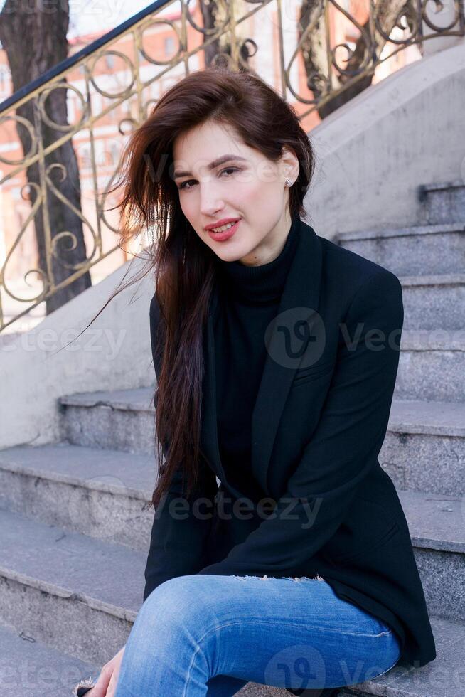 Young fashion brunette business woman against business center at sunset photo