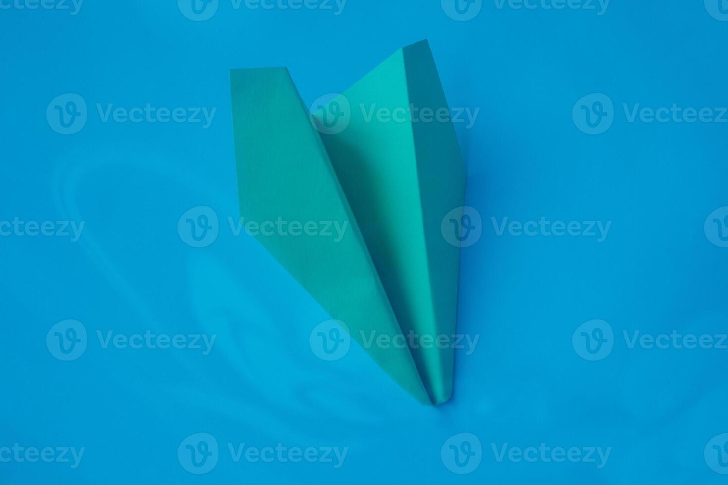 Yellow origami plane on a blue background. photo