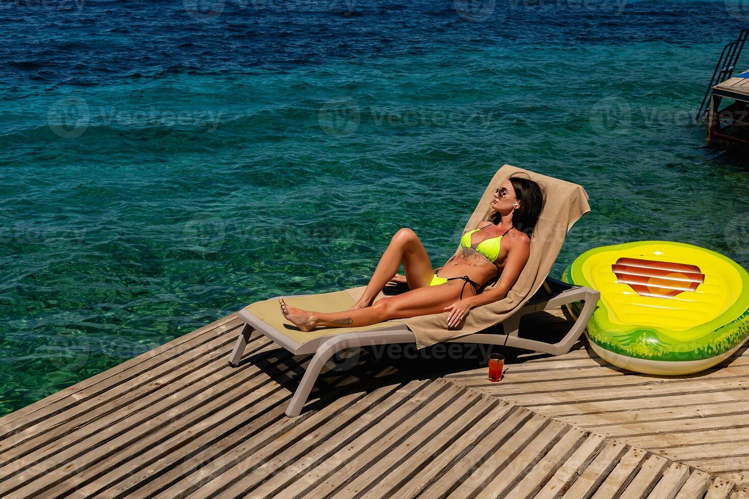Young sexy girl in a light green bikini on the ocean photo