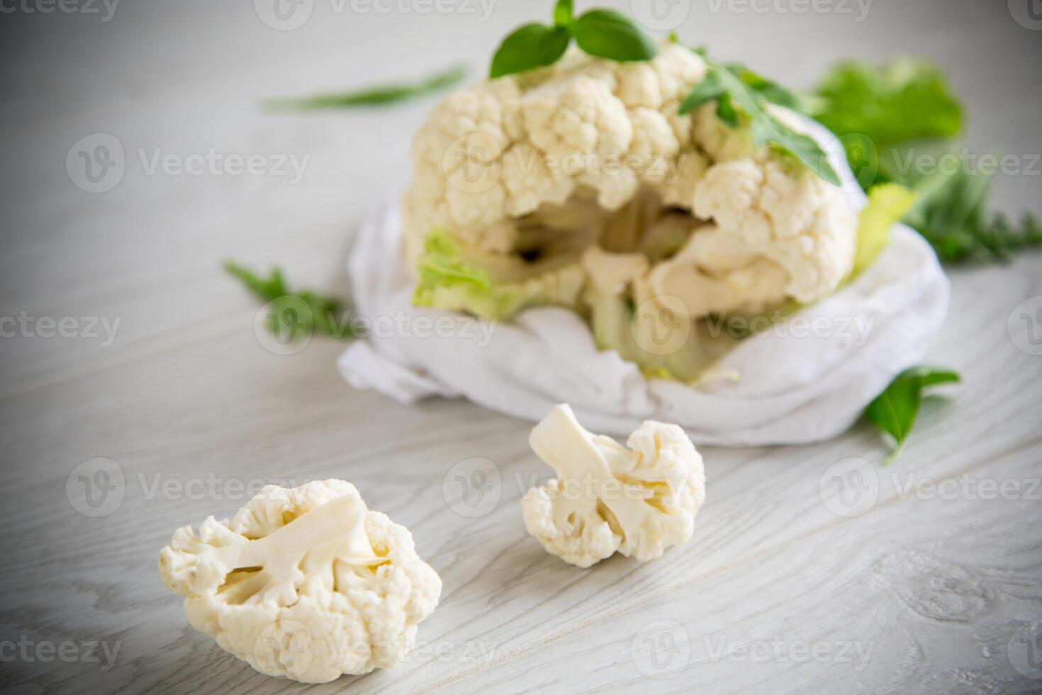 inflorescences of small cauliflower on a light wooden table photo