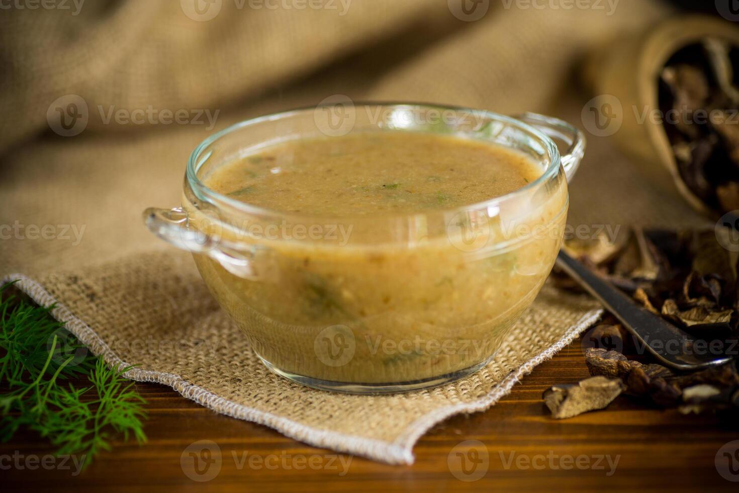hot homemade vegetable vegetarian soup with dried mushrooms in a glass bowl photo