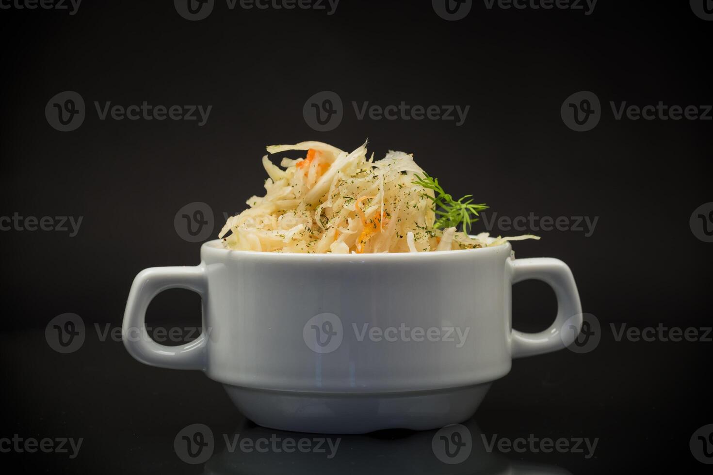 sauerkraut with carrots and spices in a white bowl photo