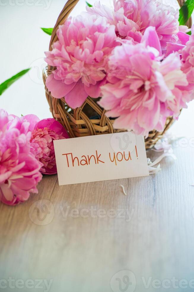 several branches of blooming pink peonies on a wooden table photo