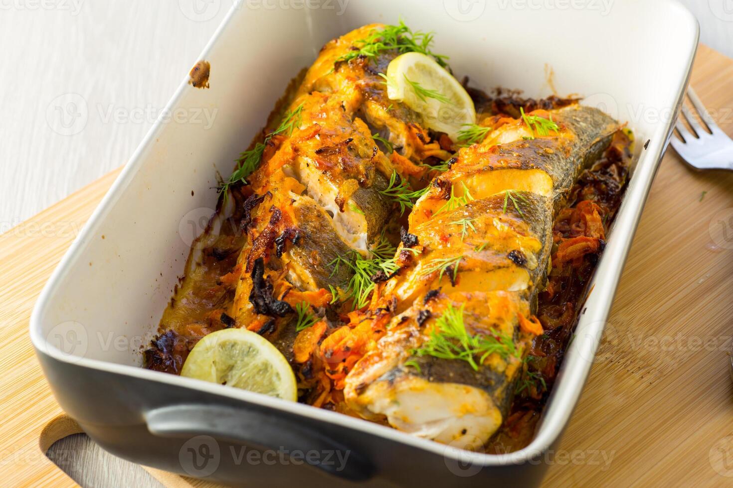 fish baked with spices and vegetables in the oven. photo