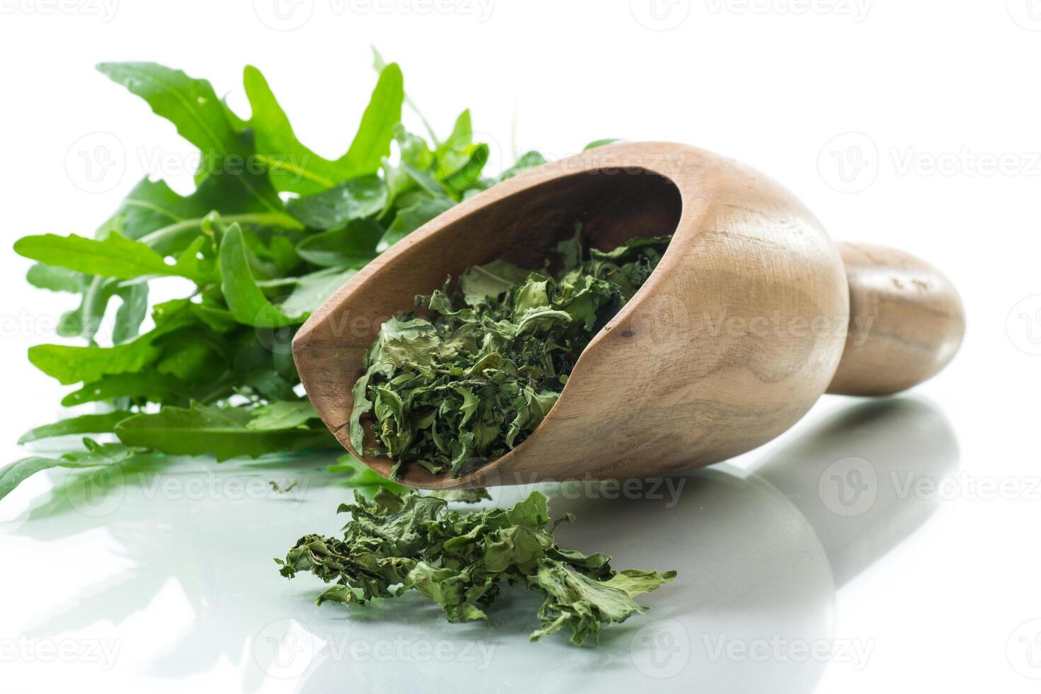dried green organic arugula, seasoning, on white background. photo