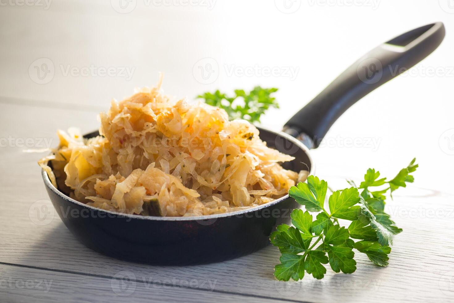 cabbage stewed with spices and carrots in a frying pan , photo